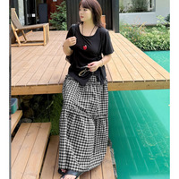 アシンメトリーな半袖Tシャツとチェック柄スカートのセットアップ